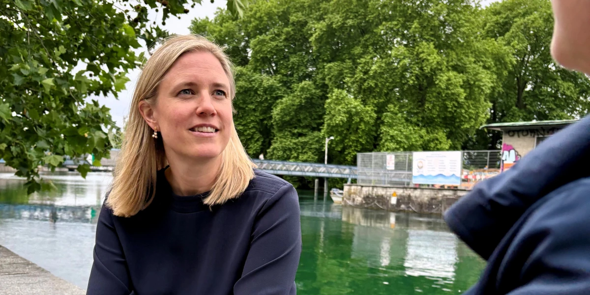 Zwei Frauen unterhalten sich auf einer Mauer am Fluss.