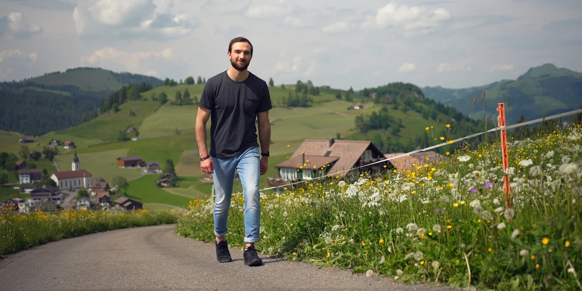 Ein Mann spaziert auf einem Feldweg nach oben.
