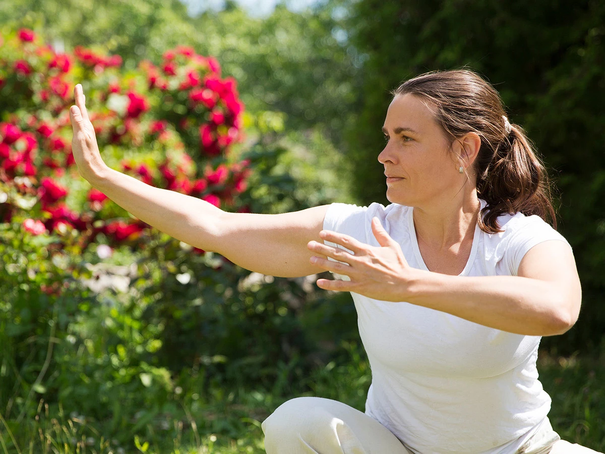 Qigong im Park Frau praktiziert im Freien Qigong.