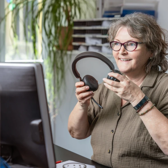 Telefonische Beratung Beraterin setzt sich das Telefonheadset auf