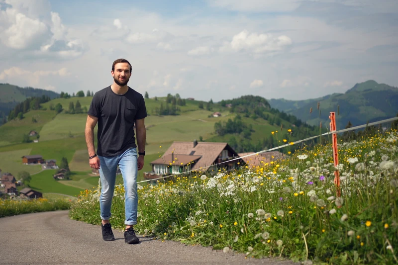 Mann spaziert einen Feldweg hoch