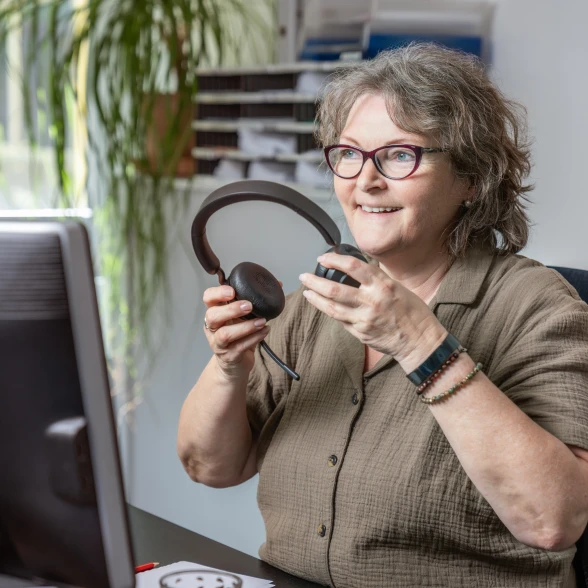 Beratung für Rheumabetroffene Beratering setzt sich den Telefon-Kopfhörer auf